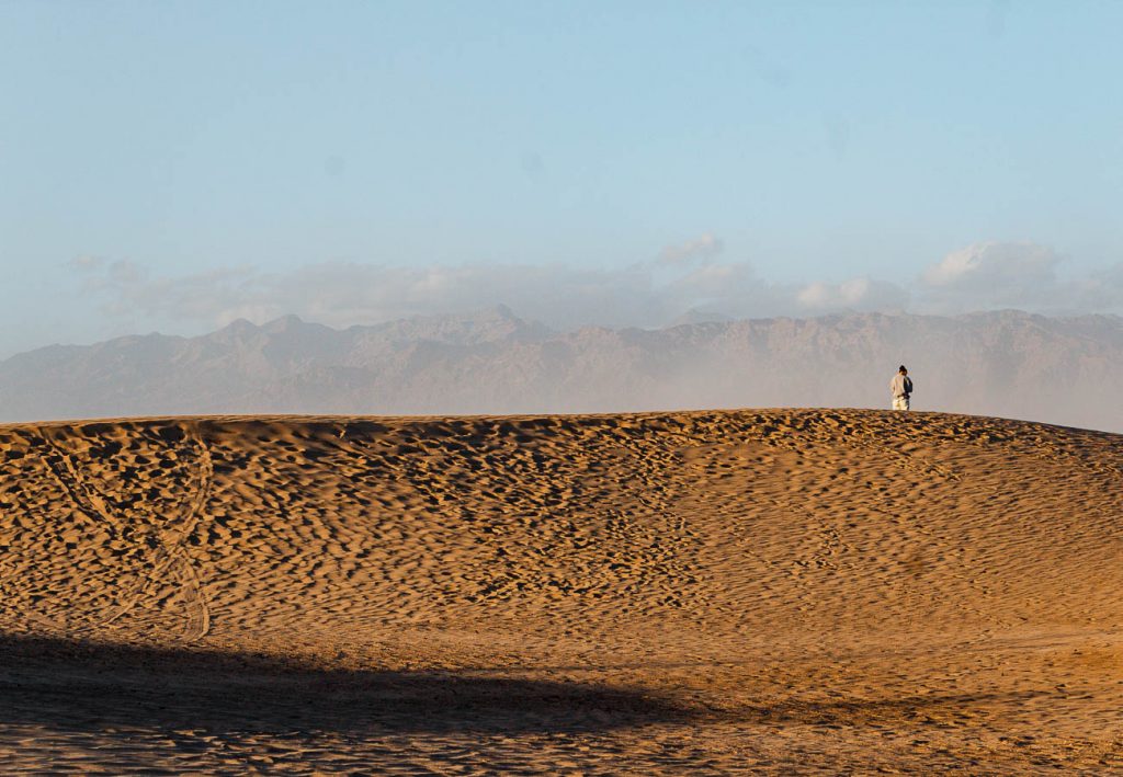 golden sand dunes with person in center right at Death Valley