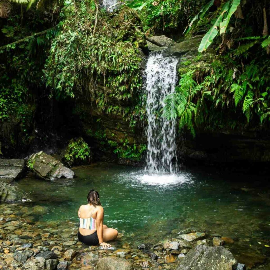 woman in front of waterfall in Puerto Rico jungle